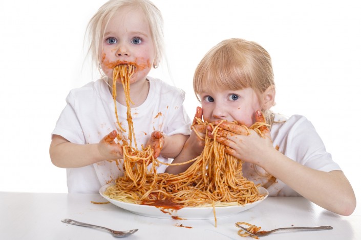 zwei Mädchen essen Spaghetti