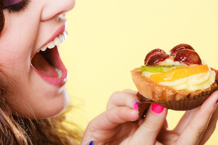 Closeup woman eating fruit cake sweet food