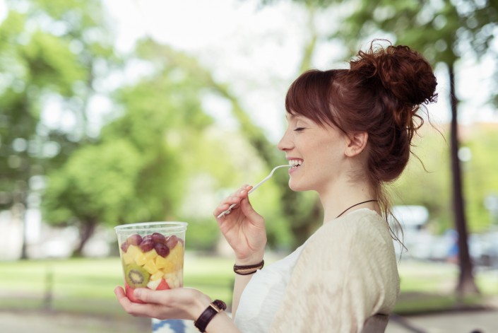 junge frau geniet einen frische obstsalat