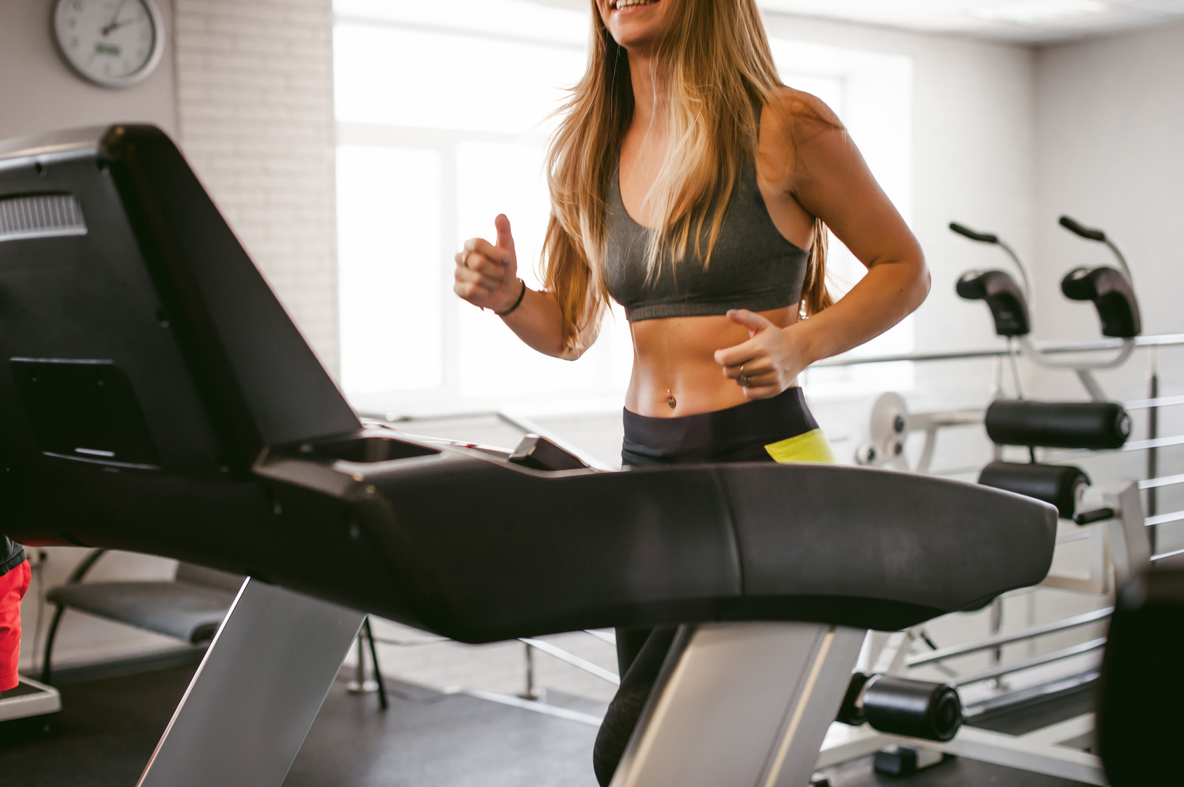 young woman is engaged fitness in gym. Performs cardio load on treadmill, running and walking with acceleration. sport, fit, lifestyle, technology and people concept