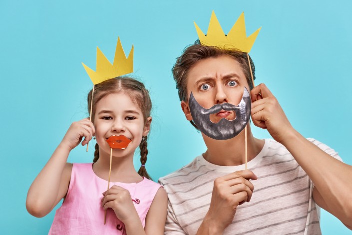Dad and child are holding paper crown