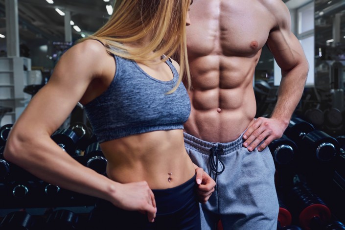 Strong man and a woman are posing with beautiful bodies.