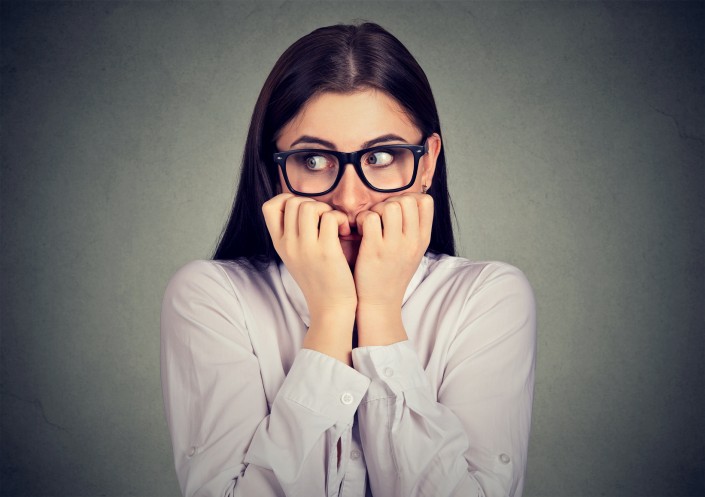 Unsure anxious woman biting her fingernails craving for something
