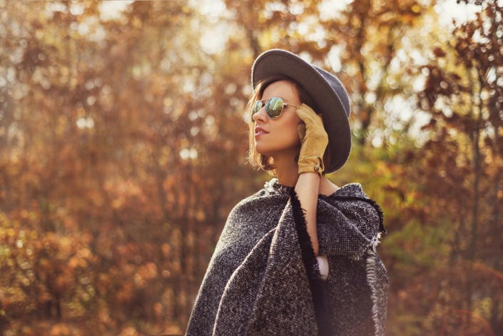 Portrait of a young, elegant woman looking away from the camera. Photogaph taken in autumn surrounding.