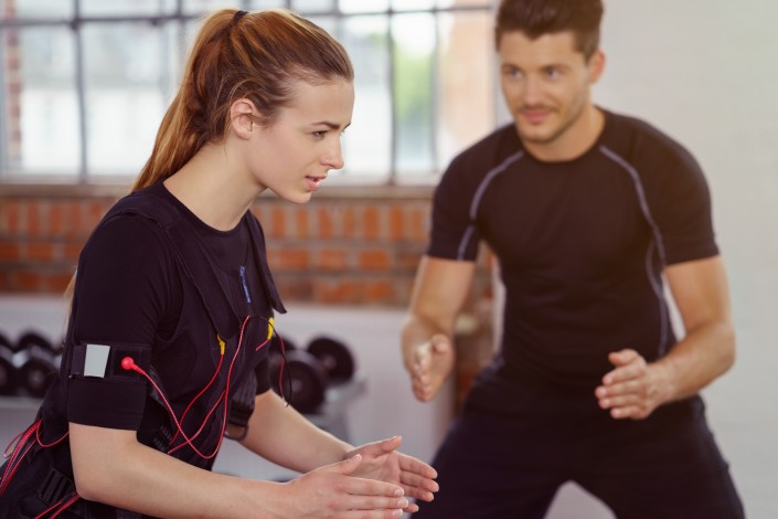 trainer betreut eine kundin beim ems-training im studio