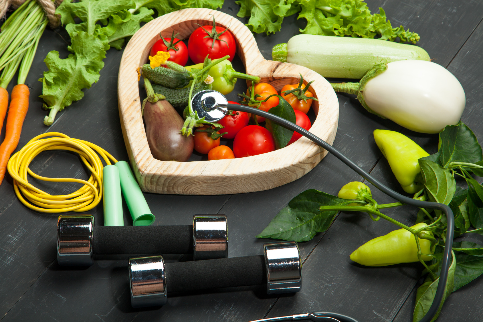Fresh vegetables. Diet, a healthy lifestyle. Sport, dumbbells and skipping rope on a black background