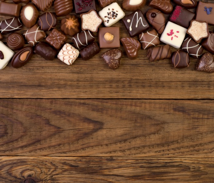 Various chocolates on wooden background