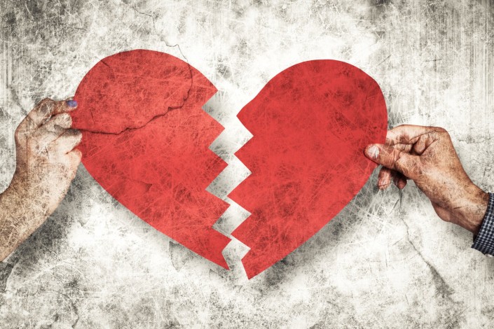 Composite image of two hands holding broken heart