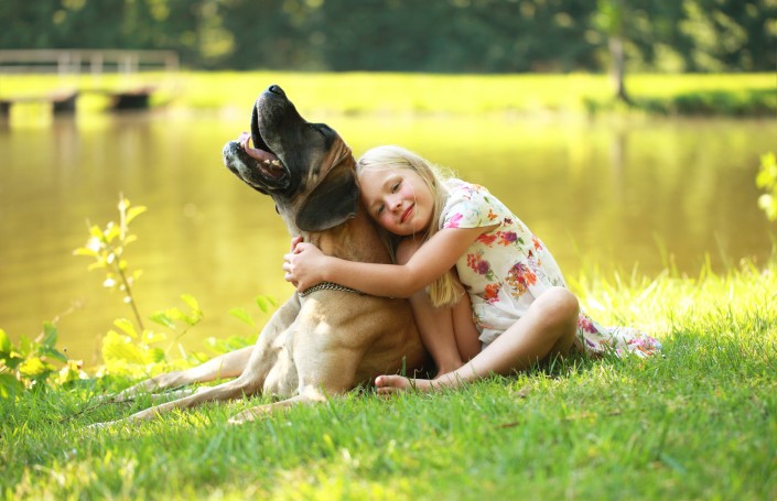 glückliches Mädchen mit ihrer Dogge am See