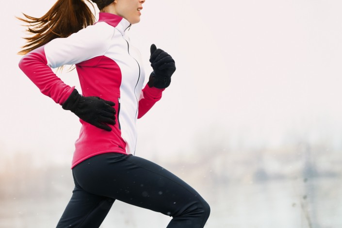 Winter running athlete woman on cold run jogging fast with speed