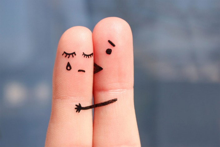 Finger art of displeased couple. Woman cries, man reassures her. He kisses and hugs her.