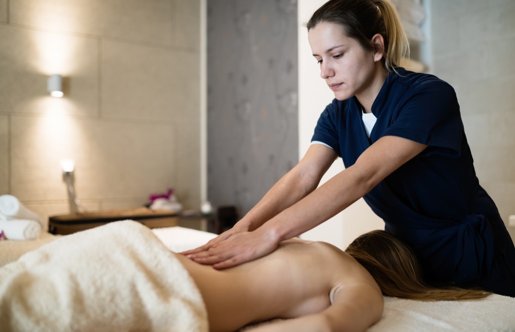 Masseur massaging back of female