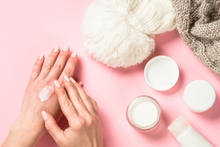 Woman using winter cream for hands.