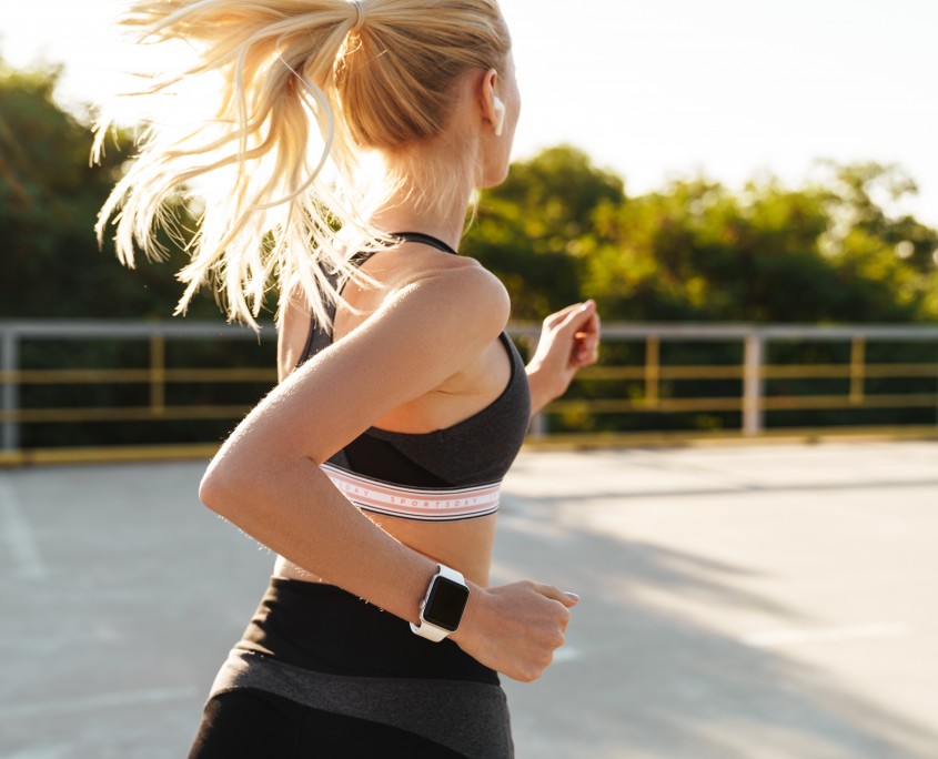 Image of attractive fitness woman wearing tracksuit running outdoors