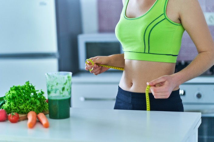 Diet woman with a green smoothie for losing weight. Vegetables detox organic fitness drinks for healthy eating