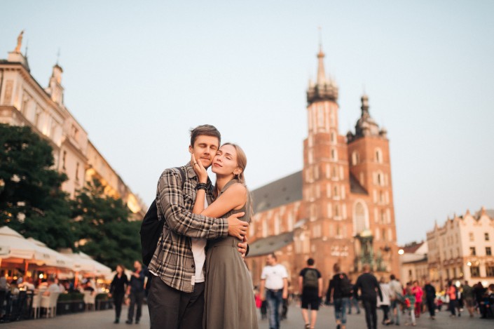 Young loving couple hugs at central square in Krakow (Cracow).