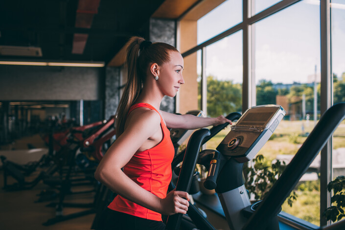 Sport girl run orbitrek gym body fitness concept.