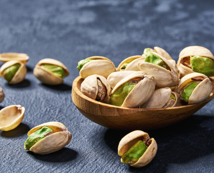 Pistachios  in wooden spoon  on black table,close-up